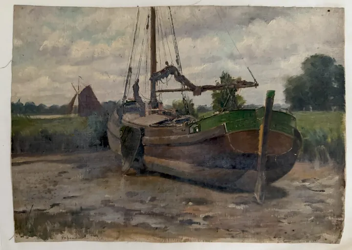 A wooden sailing barge resting on a muddy bank, a windmill and trees behind