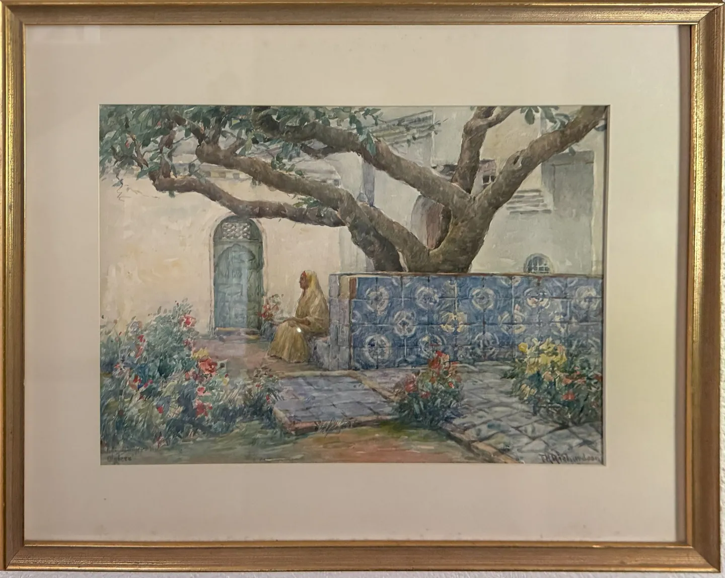 A sunny courtyard with a tiled bench and flowers, a figure seated under a large tree