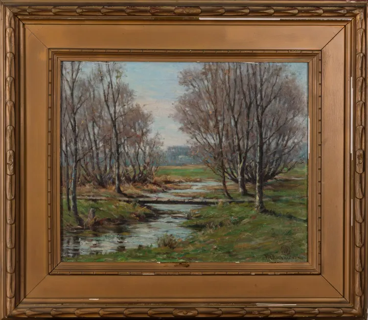 A stream winding through a meadow between slender autumn trees
