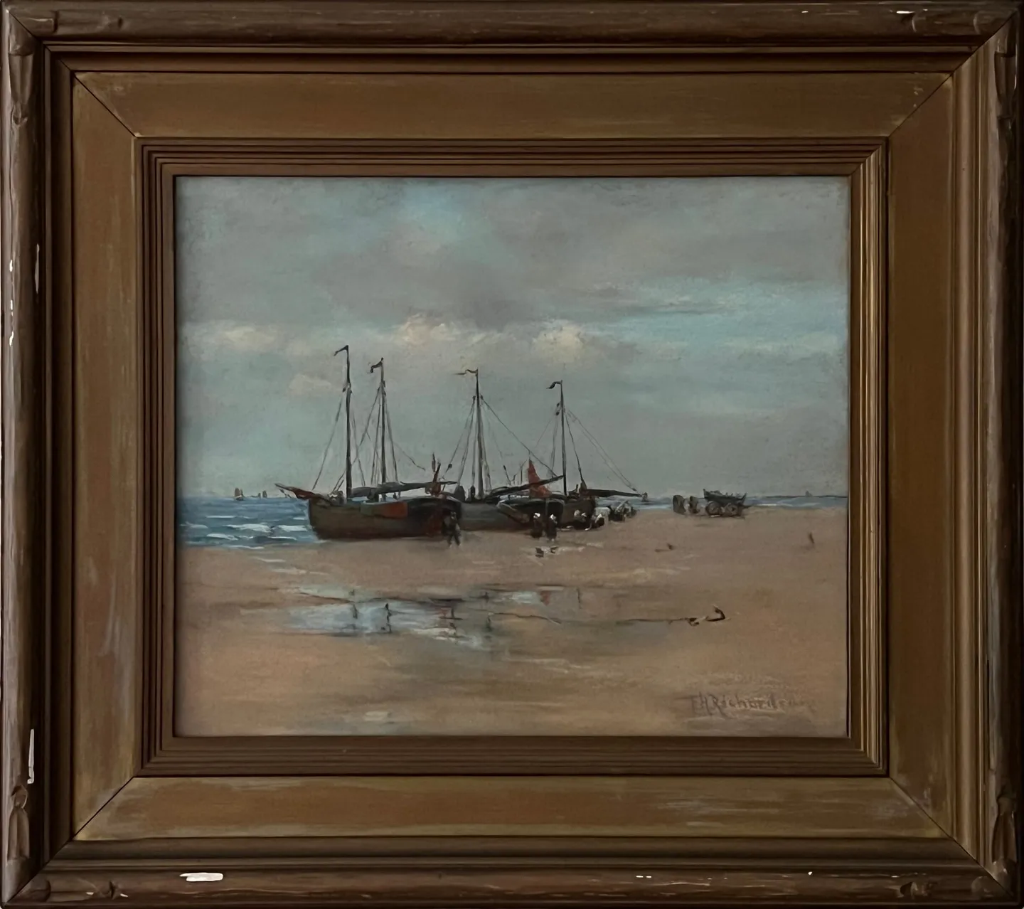 Three fishing boats drawn up on a wide beach at low tide
