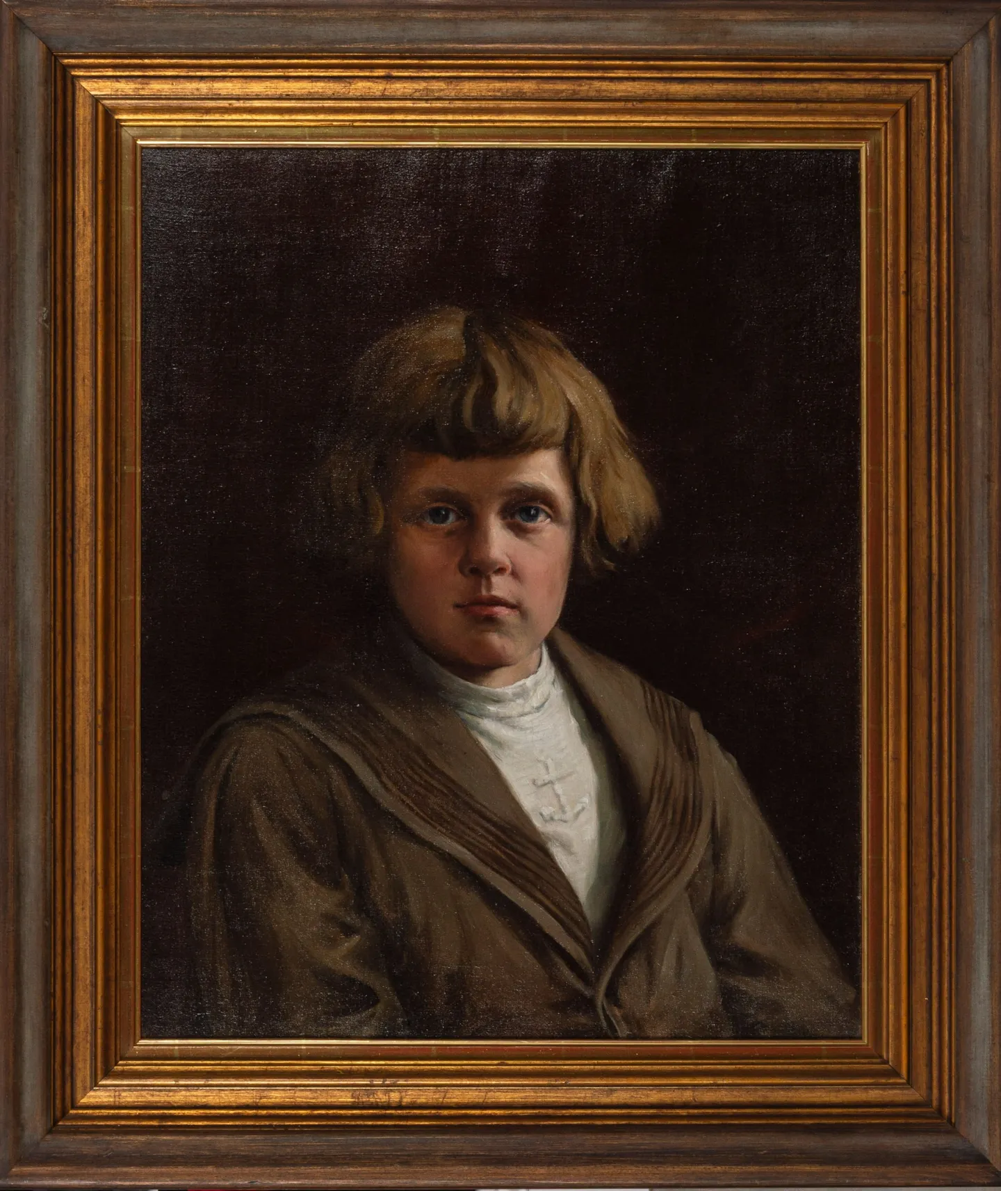 A boy with a blond fringe in a brown sailor-collared jacket