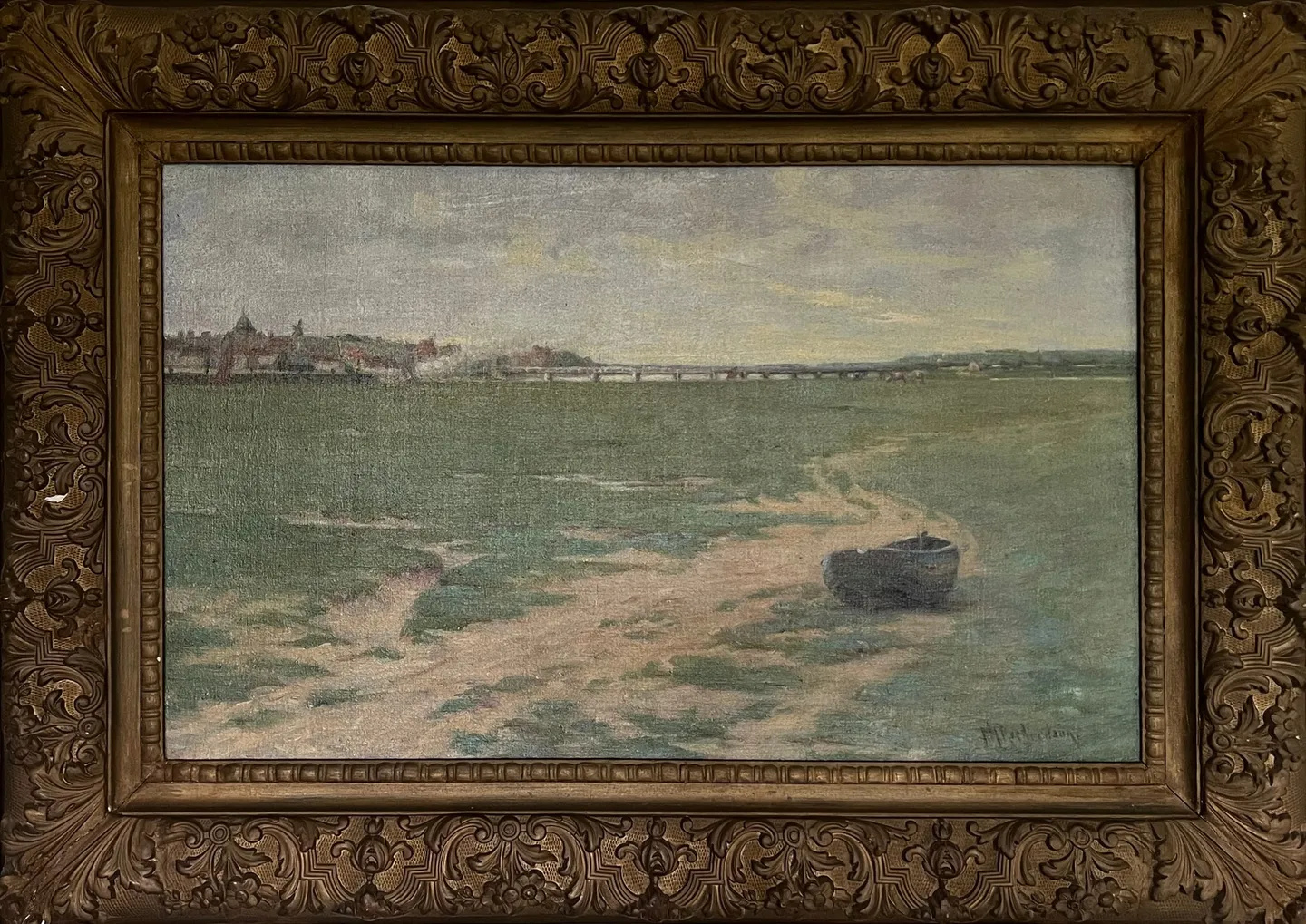 A small boat on sandy tidal flats, a town on the far horizon