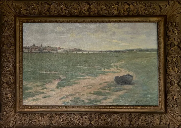 A small boat on sandy tidal flats, a town on the far horizon
