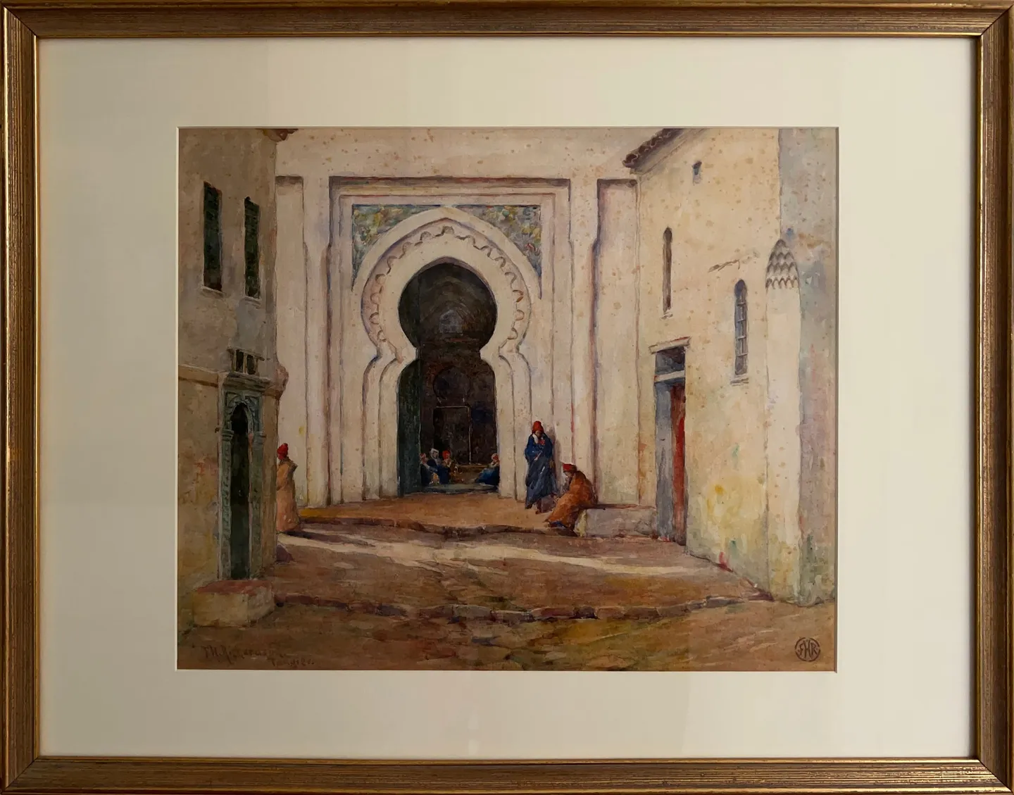 A carved Moorish archway in a white-walled street, with seated figures