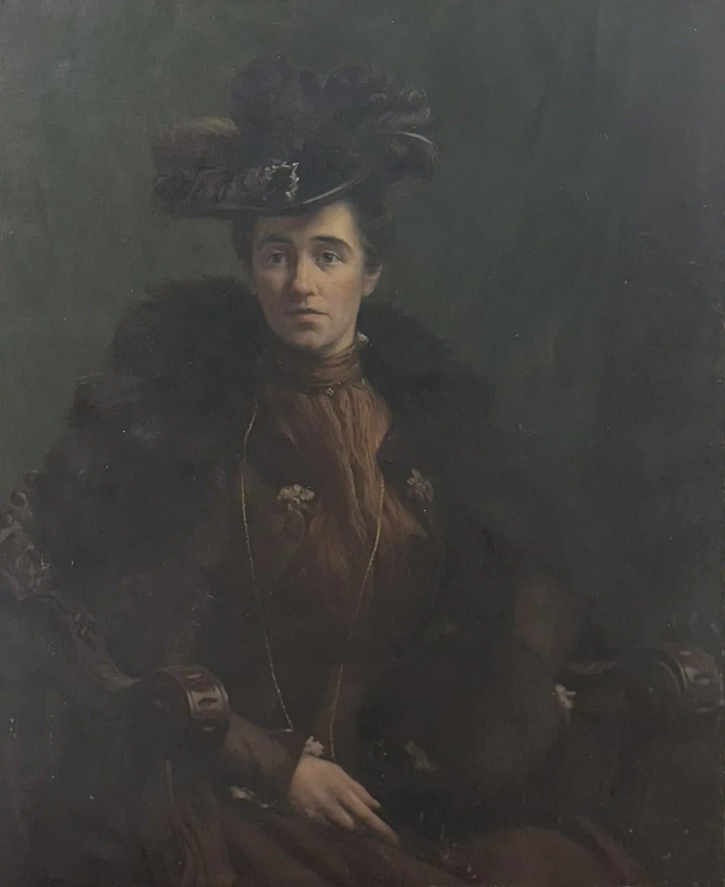 A woman in a black plumed hat and fur-trimmed coat