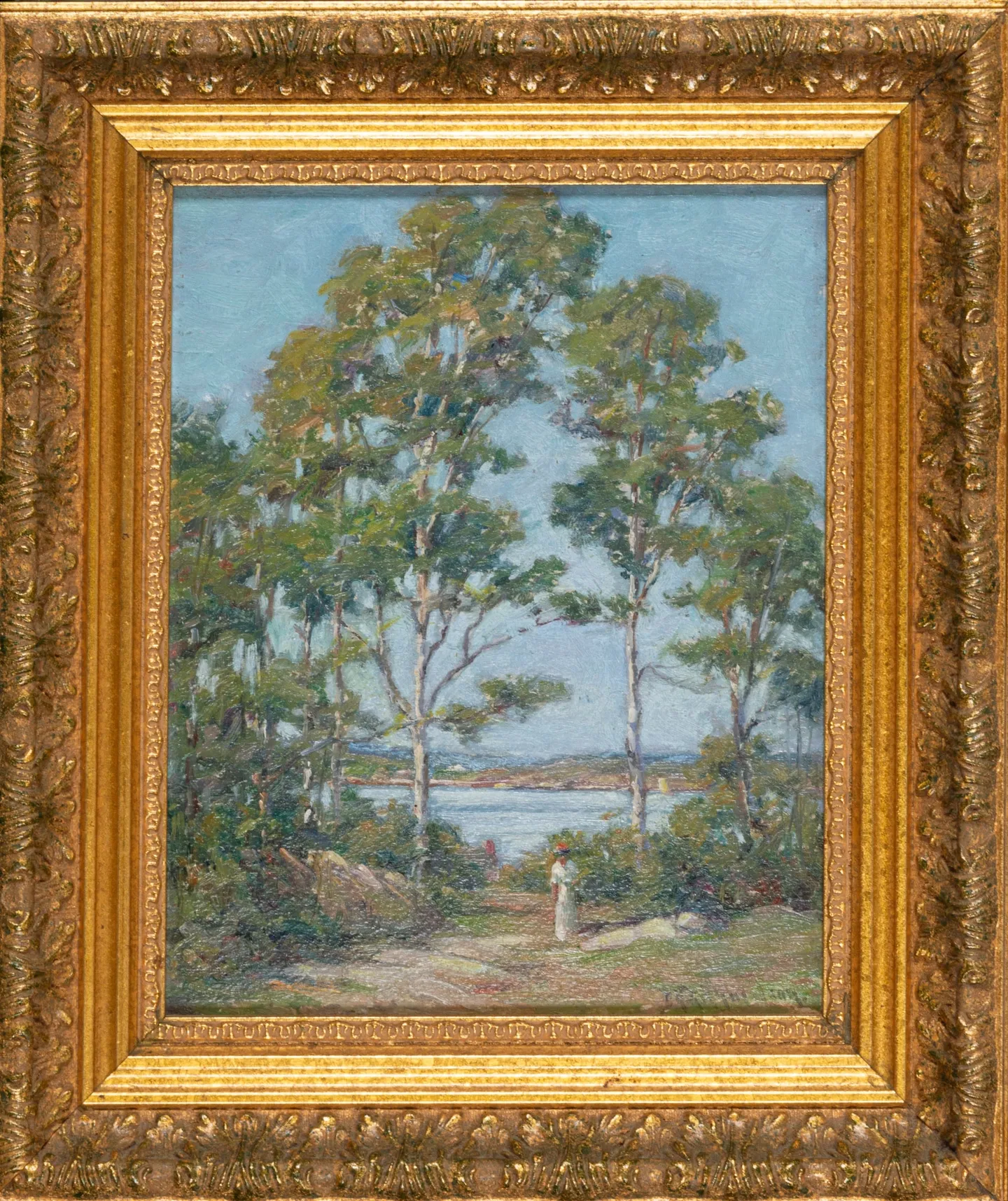 Tall trees framing a view of the water, a small figure on the path