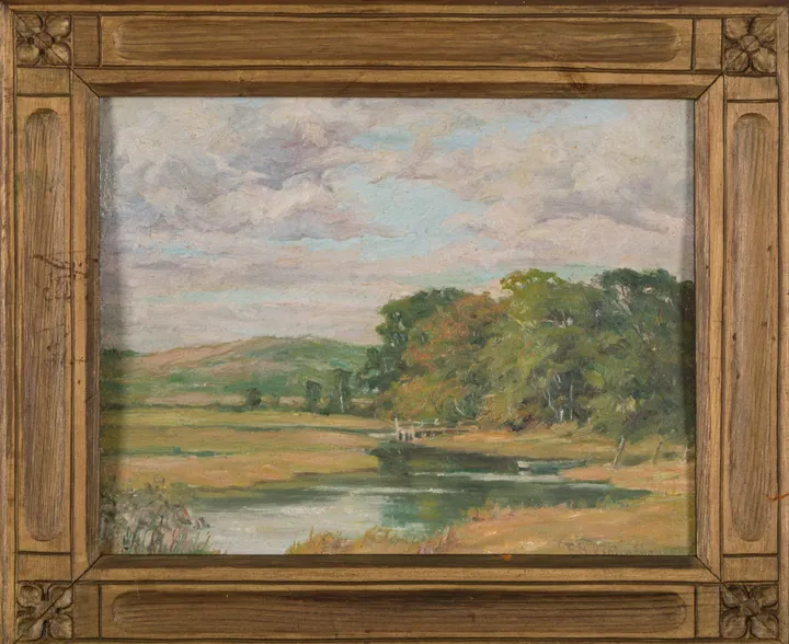 A river winding through green meadows and trees under a pale summer sky