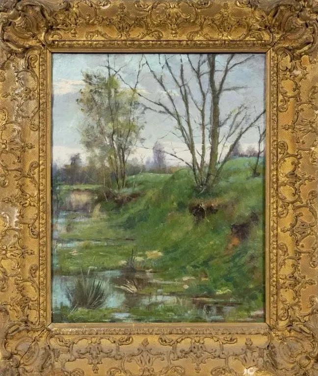 Young spring trees on a green bank beside a marshy pool