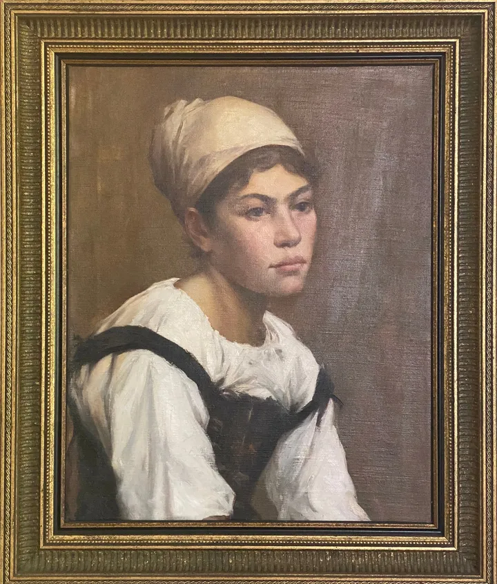 A young woman in a cream headscarf and white blouse with dark straps